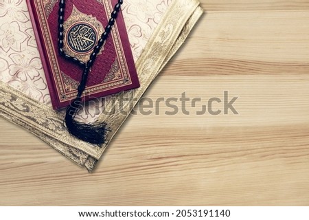 Holy Quran book with arabic calligraphies translation and Rosary beads