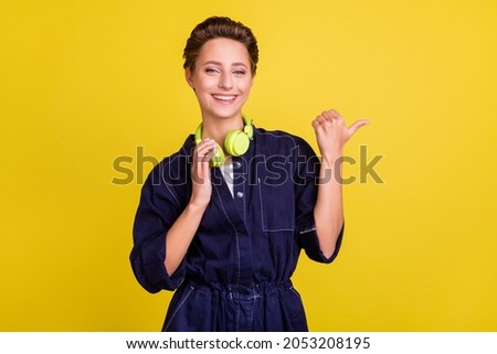 Portrait of attractive cheerful girl listening melody demonstrating copy space isolated over bright yellow color background