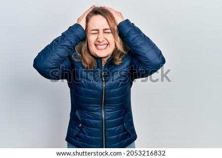Middle age caucasian woman wearing casual clothes suffering from headache desperate and stressed because pain and migraine. hands on head. 