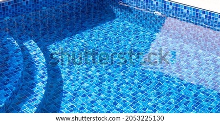Vinyl lined pool. Outdoor photo of a mosaic-patterned residential swimming pool. Swimming pool with internal steps. Feeling of moving water.
