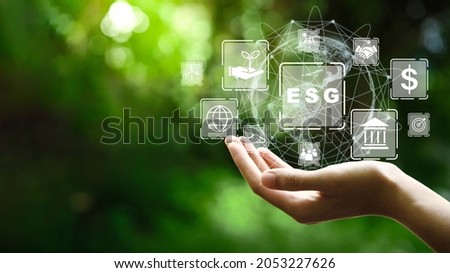 ESG icon concept in the hand for environmental, social, and governance in sustainable and ethical business on the Network connection on a green background. Royalty-Free Stock Photo #2053227626