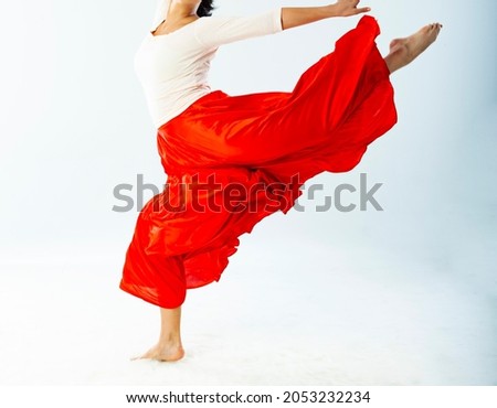 A woman in a red skirt is dancing