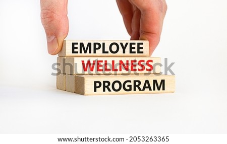 Employee wellness program symbol. Concept words 'Employee wellness program' on wooden blocks. Businessman hand. Beautiful white background. Copy space. Business and employee wellness program concept.