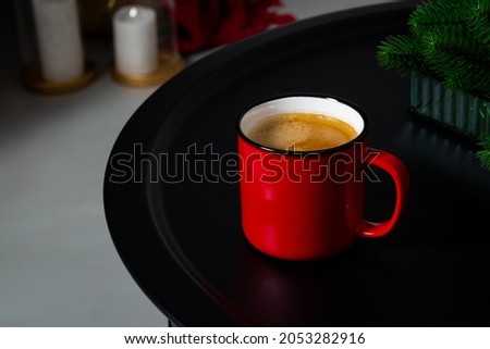 A red cup of coffee stands on the table. Cozy Christmas interior. High quality photo