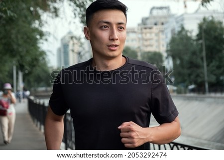 An Asian man running in the city, in the evening. Kazakhstan