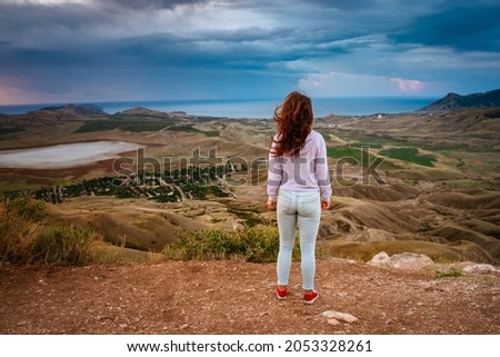  Young woman on top of a mountain at dawn with amazing mountain scenery and valley