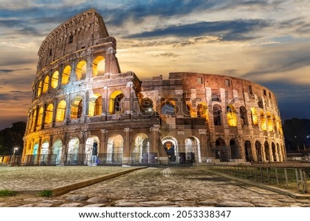 Illuminated Roman Coliseum under the clouds at sunrise, Italy Royalty-Free Stock Photo #2053338347