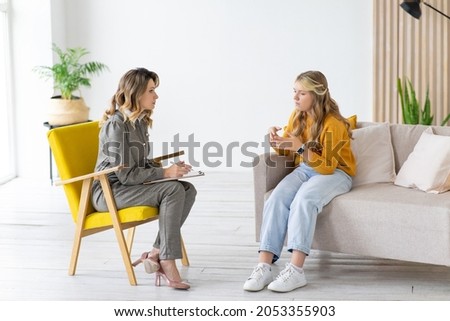 Teenage girl talks to school counselor. Child psychologist at work. Royalty-Free Stock Photo #2053355903