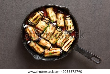 Eggplant (aubergine) rolls with cheese and greens in cast iron pan over dark stone background. Top view, flat lay
 Royalty-Free Stock Photo #2053372790
