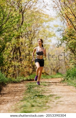 Fit woman jogging exercising running cardio workout focused female runner endurance training