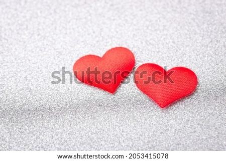 Two red hearts on silver background. Concept of love between people, devotion, romantic relationships