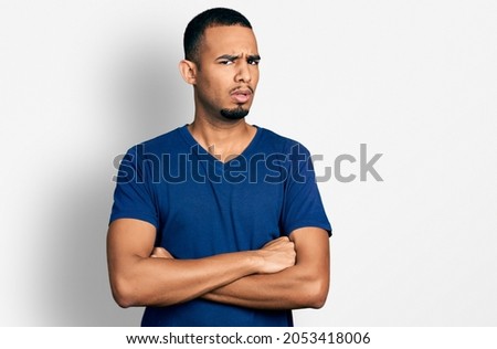 Young african american man with arms crossed gesture in shock face, looking skeptical and sarcastic, surprised with open mouth  Royalty-Free Stock Photo #2053418006