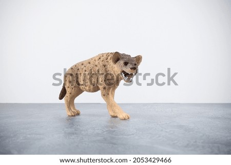 Toy spotted hyena on gray surface