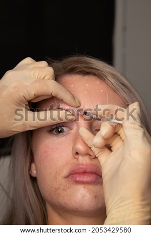 
Young beautiful caucasian woman receiving cosmetolory injections. Lip filler and anti aging injection cosmetic beauty procedures. Forehead wrinkle filler being injected.