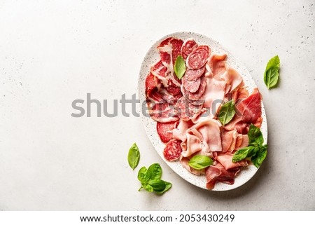 Appetizers with differents antipasti, charcuterie, snacks and red wine on white background. Sausage, ham, tapas, olives and crackers for buffet party. Top view, flat lay Royalty-Free Stock Photo #2053430249