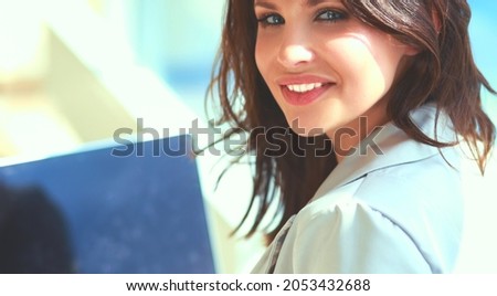 Young smiling woman sitting with laptop computer