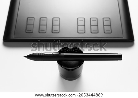 Graphic tablet with pen for illustrators and designers on white background. Close up.