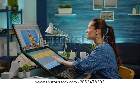 Graphic designer using touch screen for retouching work on professional pictures at studio. Media specialist working with editing software on computer for photography production.