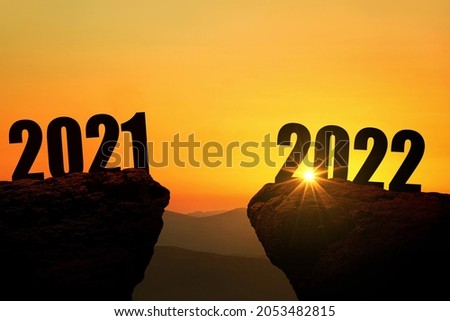 New Year's Eve 2022 on the mountain at sunset, concept. 2021 and 2022 on the cliff at sunrise, creative idea. Free space for design Royalty-Free Stock Photo #2053482815
