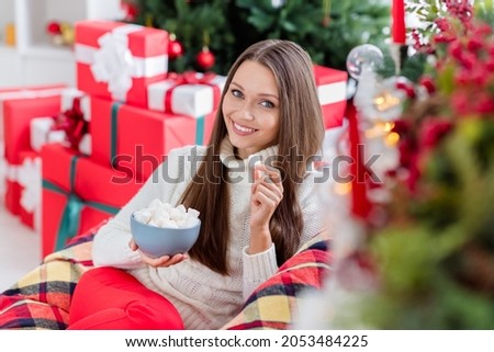 Photo of attractive adorable young woman dressed white sweater eating christmas snacks smiling indoors house home room