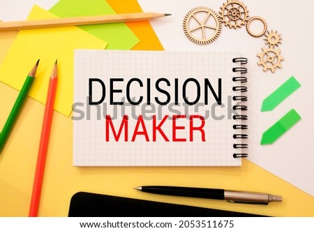Closeup on businessman holding a card with DECISION MAKER message, business concept image with soft focus background and vintage tone