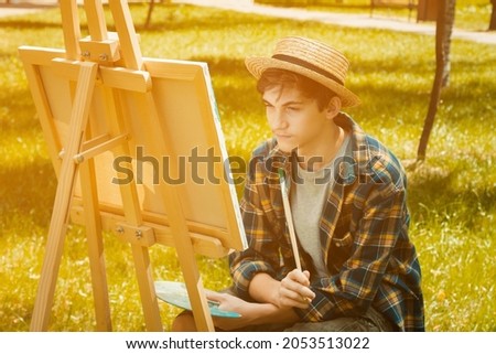 Autumn photo of the artist in the park. Photo in warm colors. Against the background of yellow foliage