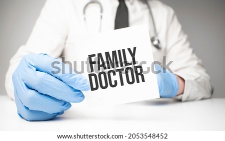 White sticker with text Family Doctor in doctor's hands with a stethoscope