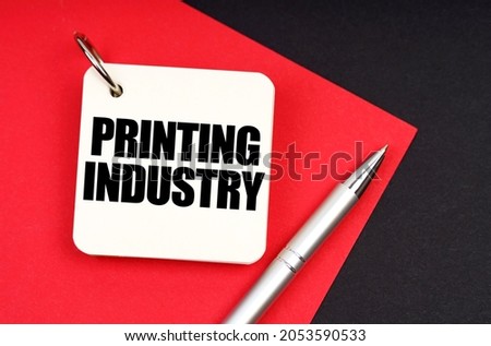 Industry and business concept. On a black and red background lies a pen and a notebook with the inscription - Printing Industry