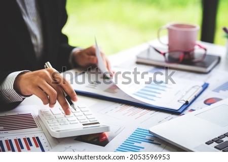 Close-up shot of woman pressing a calculator to review and summarize the cost of mortgage home loans for refinancing plans, lifestyle concept. Royalty-Free Stock Photo #2053596953