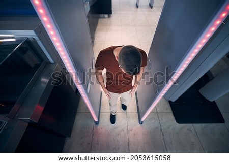 Security check point at airport. Passengers passing through gate of metal detector before flight.
 Royalty-Free Stock Photo #2053615058
