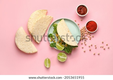 Plate with tasty vegetarian taco and sauce on color background