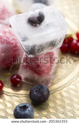 Fresh berry fruits frozen in ice cubes