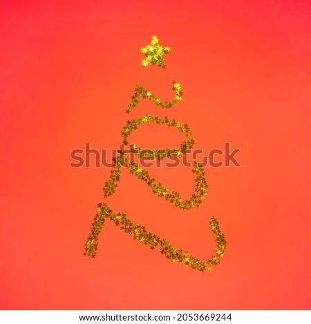 Creative Christmas and New Year holiday concept. Christmas tree in shape numbers 2022 from gold stars spangles on red background. Flat lay. top view