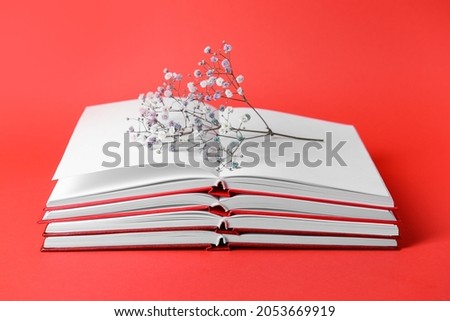 Blank books and flower on color background