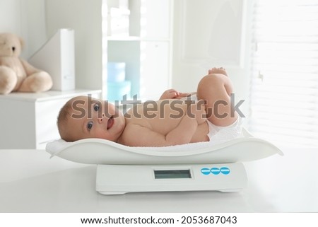 Cute little baby lying on scales in clinic