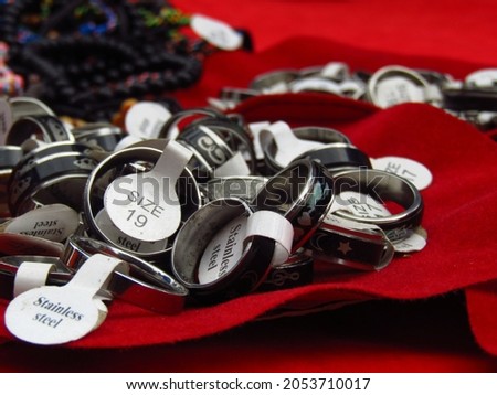 Photo of a pile of stainless steel rings of various sizes and models on a red background