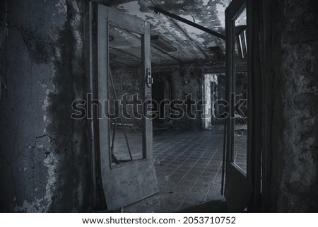Terrible abandoned room. Broken door. A room in an abandoned house. Shabby walls.