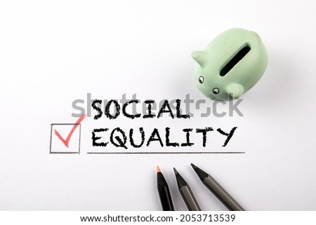 Social Equality. Piggy bank and pencils on a white background.