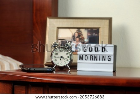 lightbox with good morning words on bedside table in bedroom