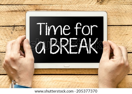 Tablet pc with text "Time for a break" which holding man Royalty-Free Stock Photo #205377370