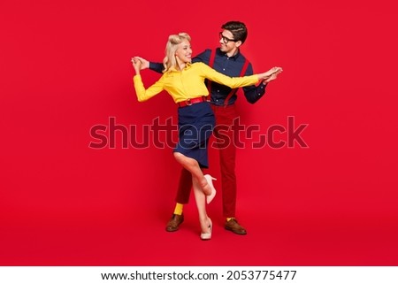 Photo of charming adorable young lady guy dressed pinup outfits holding hands arms dancing boogie woogie isolated red color background Royalty-Free Stock Photo #2053775477
