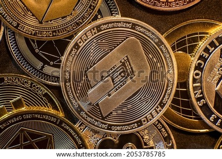 Horizontal view of cryptocurrency tokens, including Dash, Bitcoin, dogecoin, and Ethereum seen from above on a black background. High quality photo