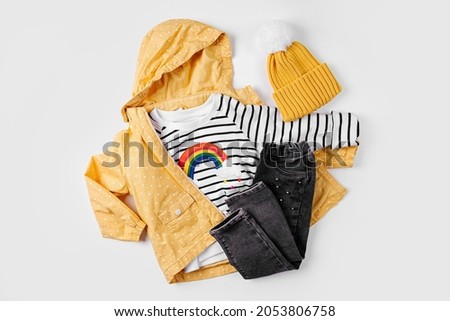 Yellow jacket, jeans and jumper on white background. Set of children's clothes for autumn. Fashion kids outfit.