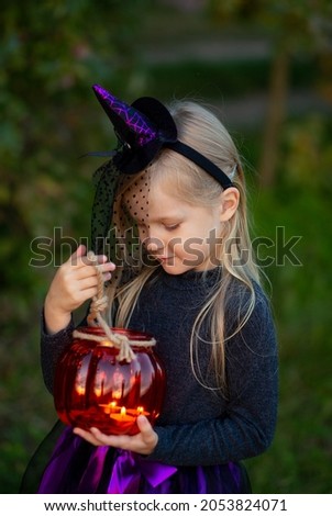 girl dressed as a witch with a flashlight