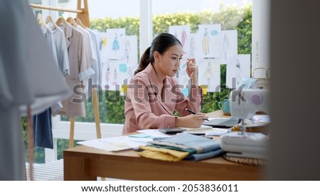 Woman seller SME retail store owner work hard worry stress in bad news on laptop at home office desk. Asian people crisis tailor job issue feel tired tough and upset in cash money loss or loan debt. Royalty-Free Stock Photo #2053836011