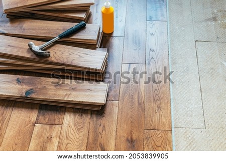 The process of house renovation with changing of the floor from carpets to solid oak wood. Beautiful golden handscraped oiled European oak brushed for added texture and fine definition of wood grain Royalty-Free Stock Photo #2053839905