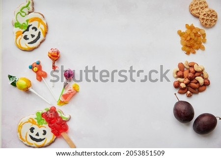 Trick or treat concept lettering. Healthy and unhealthy food in comparison: Alternative to sweets and candies - nuts, fruits and dried fruits. Copy space. High quality photo