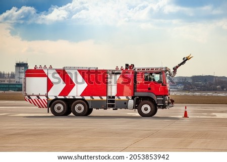 New red fire truck at the airport. Outdoor. Copy space. Transportation car. Airport fire engine. Firetrack Royalty-Free Stock Photo #2053853942