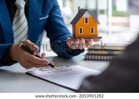 Real estate company to buy houses and land are delivering keys and houses to customers after agreeing to make a home purchase agreement and make a loan agreement. Discussion with a real estate agent 