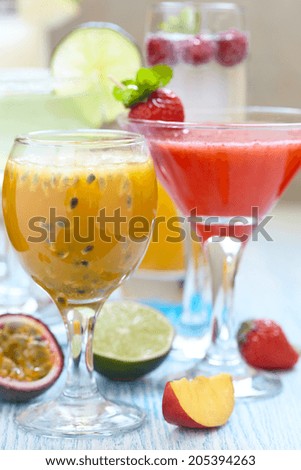 Fresh tropical cocktails with orange, peach, passion fruit, strawberry and raspberry